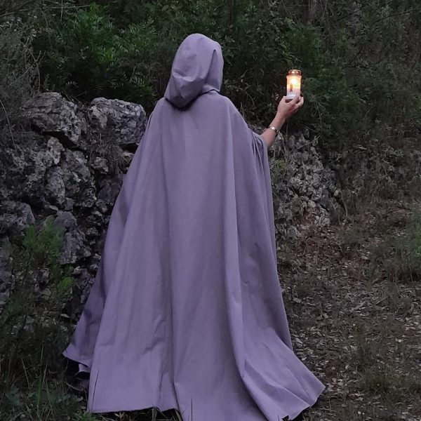 Personne avec longue cape grise une bougie à la main