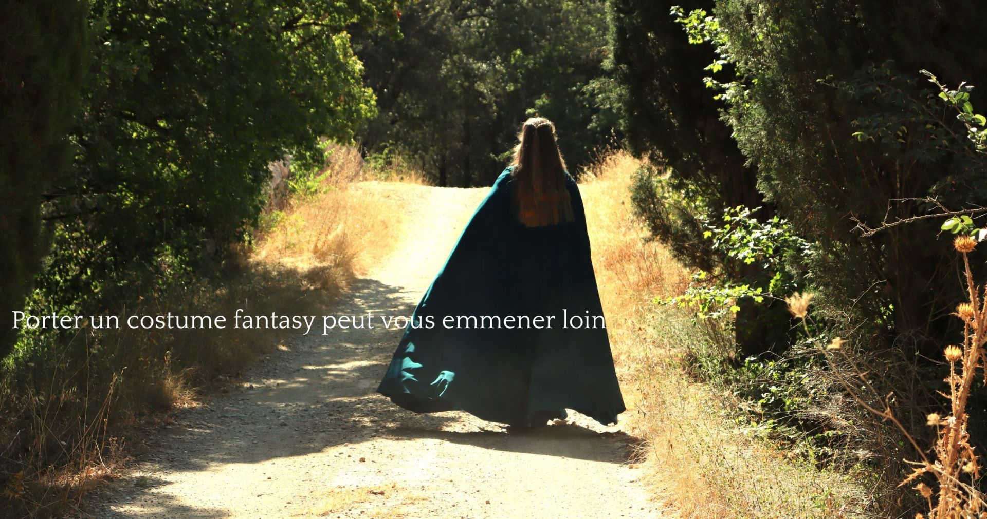 Jeune femme marchant de dos, sa longue cape médiévale verte flottant au vent, un titre précise que Porter un costume fantasy peut vous emmener loin