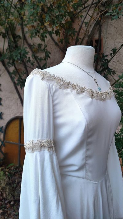 Robe fantasy blanche avec ruban brodé doré et perles argent à l'encolure et au tour des bras sur mannequin