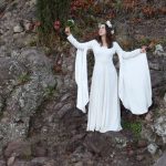 Mariée en robe médiévale fantastique levant son bouquet