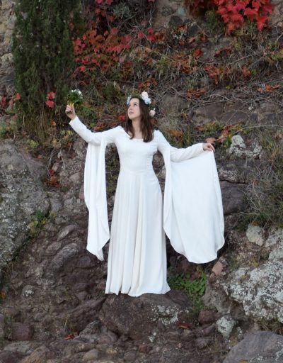 Mariée en robe médiévale fantastique levant son bouquet