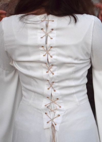 Détails de la robe fantasy blanche vue de dos: un laçage avec galon blanc et doré