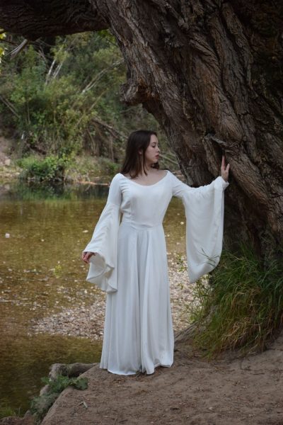 Femme en robe de princesse aux manches longues de style médiéval, au bord de la rivière