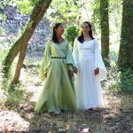 Deux jeunes filles dans les sous bois, l'une vêtue d'une robe fantasy verte et l'autre d'une robe médiévale blanche