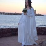 Une mariée en robe blanche romantique fantasy marche au bord de la mer
