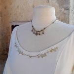 Détails de broderie or sur l'encolure d'une robe blanche féérique