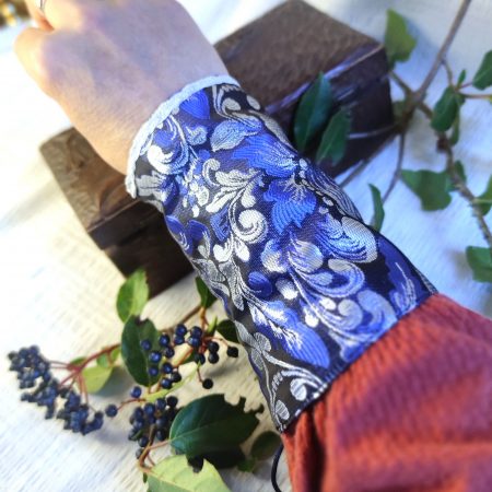 Manchette en brocard bleu et argent aux motifs fleur de lys, portée au poingnet