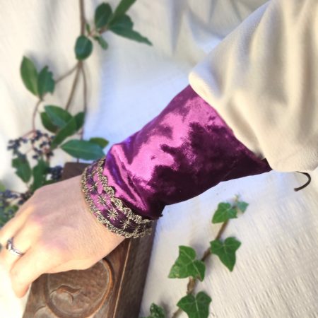 Manchette en velours pourpre avec ruban tulle noir et or, portée au poignet