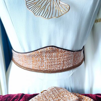 Ceinture fantasy de conte de fée en brocard cuivré et crème portée à la taille sur un mannequin revêtu d'une longue robe blanche médiévale