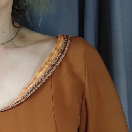 Gros plan sur les galons d'encolure de Robe médiévale couleur carmel portée