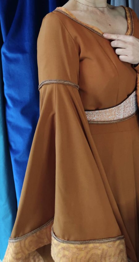 gros plan sur le galon de bras de Robe médiévale couleur carmel portée