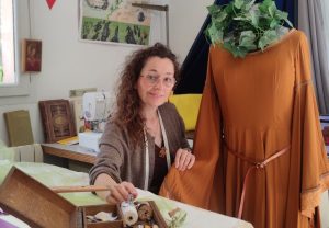 Couturière dans son atelier avec robe sur un mannequin et bite à couture