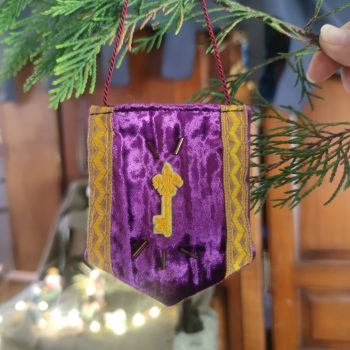 décoration en forme de bannière d'inspiration médiévale fantasy suspendue à une branche de sapin