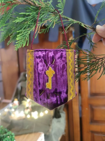 décoration en forme de bannière d'inspiration médiévale fantasy suspendue à une branche de sapin