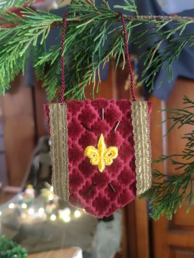 décoration en forme de bannière d'inspiration médiévale fantasy suspendue à une branche de sapin