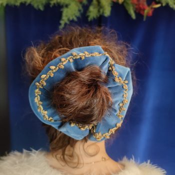 tête avec un chignon entouré d'un chouchou en velours bleu avec galon feuilles vieil or