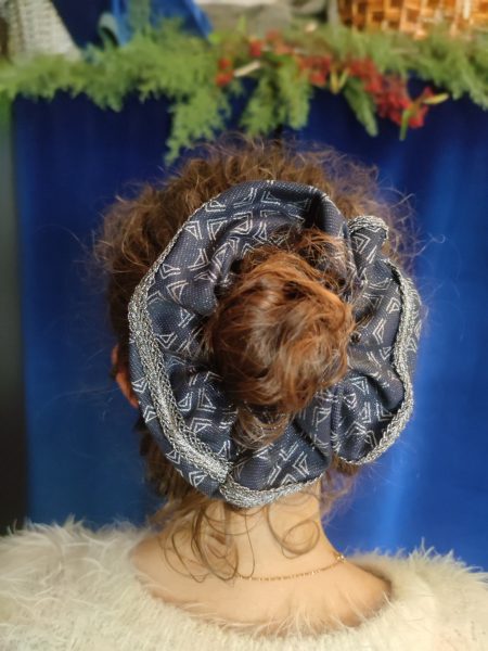 tête avec un chignon entouré d'un chouchou en brocard marine et argent avec galon argent
