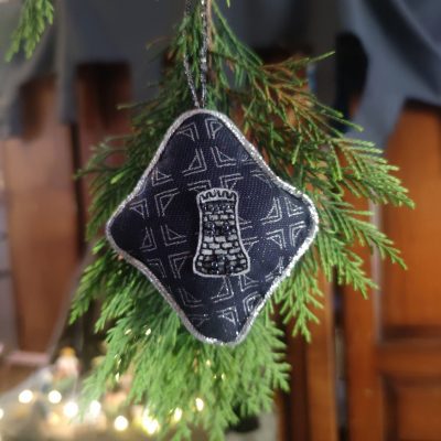 décoration en tissu d'inspiration médiévale fantasy suspendue à une branche de sapin