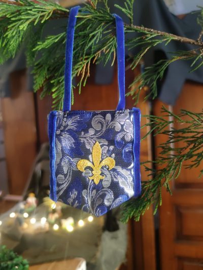 décoration en forme de bannière d'inspiration médiévale fantasy suspendue à une branche de sapin